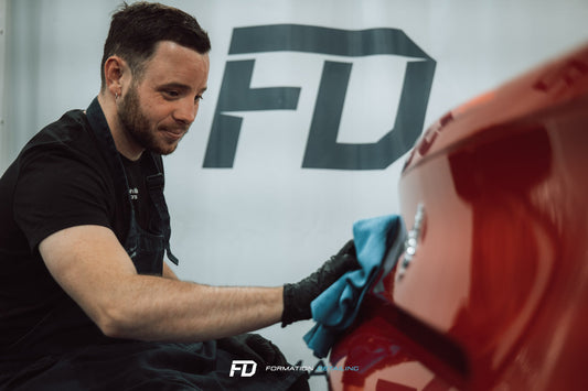 Formateur encadrant un apprenti au pollissage automobile lors d'une formation professionnelle SP Formation à Trappes dans les Yvelines