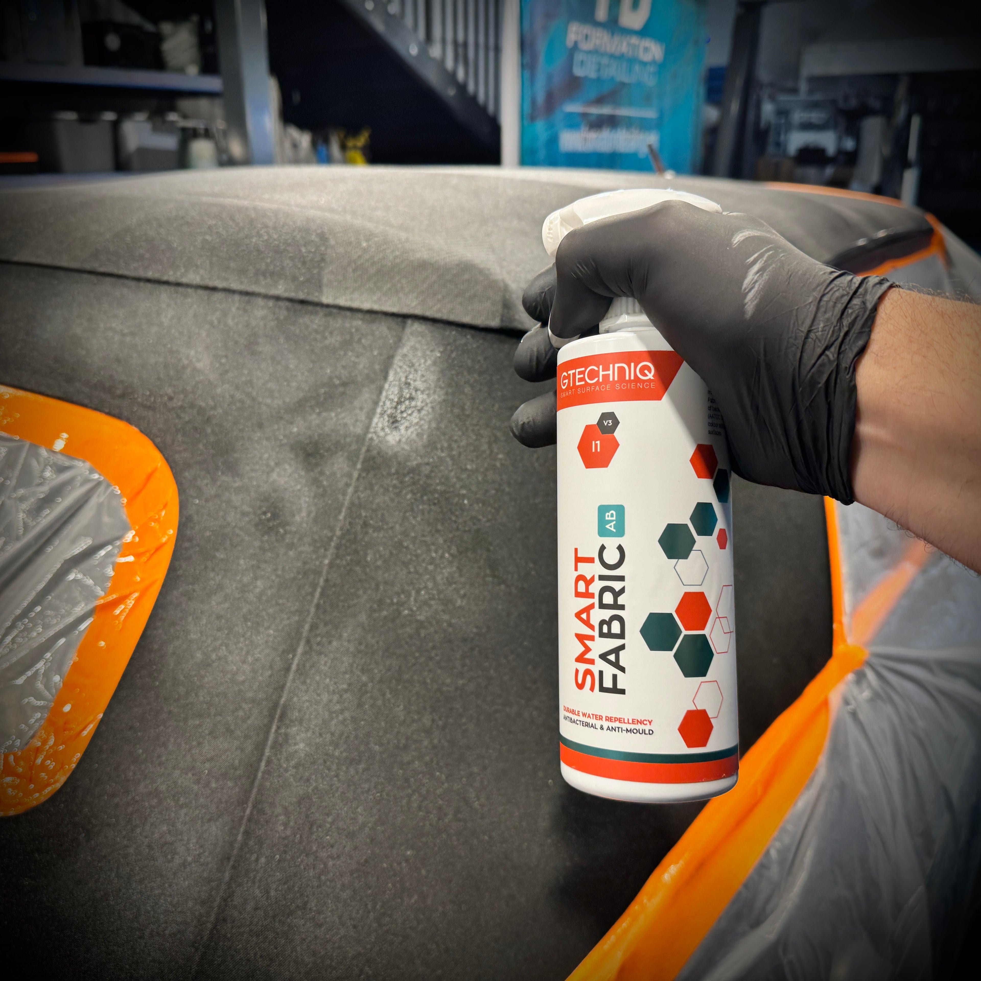 Capote de cabriolet en tissu traitée avec le Gtechniq I1 Smart Fabric, effet hydrophobe visible avec gouttes d'eau perlant sur la surface